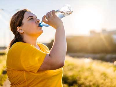 A woman drinking a water bottle after a workout